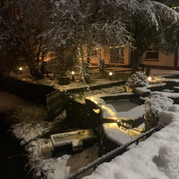 A charming Irish town blanketed in snow, adorned with Christmas decorations and twinkling lights